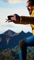 Vertical Reckless adventurer losing balance to take a picture and dropping phone off a cliff, falling down from a high altitude mountain range. Foolish hiker tries to take photos of a landscape. Camera A. video