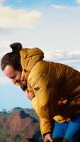 Vertical Reckless unprepared hiker stumbles near the edge of a high altitude cliff, caught off guard by strong winds. Unequipped for the extreme conditions, losing balance on mountain top. Camera B. video