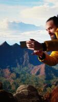 Vertical Foolish hiker acting careless dropping smartphone and losing balance, person unequipped for the harsh mountain environment. Risks of trekking with a technology obsession in nature. Camera A. video