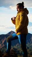 Vertical Male trekker takes in the breathtaking mountain landscape on rocks, enjoying the scenic background, crisp air and rugged peaks. Excitement of discovering new horizons. Camera A. video