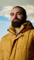 Vertical Explorer stands on a mountain peak taking in the fresh air and panoramic scenery. Hiker admires the stunning landscape of rugged peaks and vast sky, adventure and sightseeing. Camera B. video