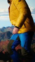 Vertical Determined trekker looks out at the epic mountain range and sightseeing, inspired by the vastness of the sky and the rugged peaks. Reward of embracing the great outdoors. Camera A. video