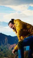 Vertical Reckless unprepared hiker stumbles near the edge of a high altitude cliff, caught off guard by strong winds. Unequipped for the extreme conditions, losing balance on mountain top. Camera A. video