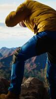 Vertical Clumsy traveler loses balance on a steep mountain peak as powerful winds knock him off course, falling and being unequipped in expedition. Unprepared hiker for the cold weather. Camera A. video