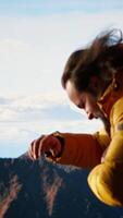 Vertical Hiker battling strong winds and cold weather tumbles over a cliff on the mountain top, dangerous risky place for trekking. Unprepared adventure seeker being foolish and tripping. Camera B. video