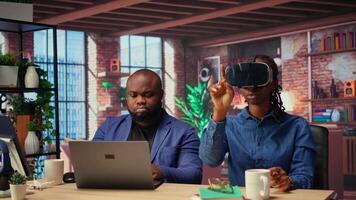 Black people integrate VR and AI into their daily job routine where the man engages in immersive 3D experience. Young focused woman reviews the animation on headset within the metaverse. Camera A. video