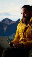 Vertical Modern online entrepreneur with technology reliance on a mountain top, always connected workaholic hiker admires the scenic landscape. Remote access high connectivity. Camera A. video
