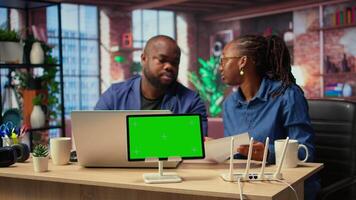 African American couple browse troubleshooting guide next to chroma key, working together to debug router issues and restore their home network. Freelancers getting angry. Camera A. video