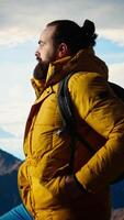 Vertical Trekker in warm clothing gazes at the panoramic mountain range, embracing the sense of adventure and the personal growth that comes with exploring most breathtaking landscapes. Camera A. video