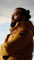Vertical Hiker stands victorious on a mountain peak with arms raised in triumph, celebrating his personal achievement with a successful climb. Scenic view and endless sky for freedom. Camera B. video