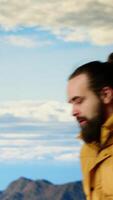Vertical Alone traveler stands on a mountain summit soaking in the stunning view of peaks, clouds and endless sky, adventure seeker. Breathtaking scenery symbolizes determination. Camera B. video