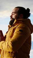 Vertical Young explorer reaching the mountain peak and meditating at the top, doing a zen meditation with calm and mindfulness. Happy content hiker loving nature for self care. Camera B. video