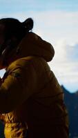 Vertical Trekker enjoys the high altitude landscape and making a phone call, panoramic mountain views and crisp air provide the perfect scene for relaxation. Using strong signal on his smartphone. Camera B. video
