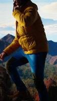 Vertical Trekker enjoys the high altitude landscape and making a phone call, panoramic mountain views and crisp air provide the perfect scene for relaxation. Using strong signal on his smartphone. Camera A. video
