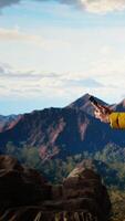 Vertical Reckless trekker risking his life focusing on his phone and falling, overwhelmed by bad weather and weak signal loses balance on a treacherous mountain peak. Foolish hiker. Camera A. video