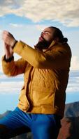 Vertical Happy climber cheering and feeling pleased while he stretches arms toward the sky, feeling the satisfaction of a personal achievement and victory. Stunning panoramic view. Camera B. video
