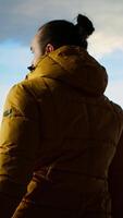 Vertical Traveler stands alone at the edge of a towering mountain range, gazing at the clouds and stunning panoramic scenery. Man showcasing personal growth and perseverance. Camera B. video