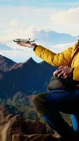 Vertical Passionate traveler documents his extreme hiking adventure with a smartphone, capturing a panoramic view. content blends nature and technology, wilderness with online followers. Camera A. video