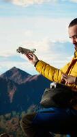 Vertical Trekking enthusiast captures his activity on using a drone footage, documenting the scenic mountain range valley. Filming beautiful aerial view vlog with remote control device. Camera A. video