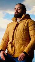 vertical orgulhoso explorador se aquece dentro a alegria do realização em pé às a montanha pico com braços levantado, atenção plena. viajante admirando deslumbrante cênico Visão e grande céu para a emoção do caminhada. Câmera b. video
