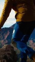 Vertical Alone traveler stands on a mountain summit soaking in the stunning view of peaks, clouds and endless sky, adventure seeker. Breathtaking scenery symbolizes determination. Camera A. video