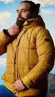 Vertical Determined traveler enjoys the solitude of a mountain summit, where the panoramic view represents adventure and personal growth. Hiker feeling cold on the windy mountain top. Camera B. video
