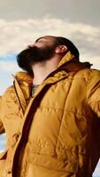Vertical Joyful hiker triumphant at the mountain top dancing and cheering, soaks in the peaceful atmosphere and fresh air. Enjoying the scenic background of towering peaks and clouds. Camera B. video
