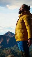 Vertical Calm peaceful explorer doing meditation session for stress relief in nature, relaxing for wellness and balance on top of the mountain. Young hiker traveler meditating for mindfulness. Camera A. video