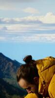 Vertical Trekker in warm clothing takes in the sweeping mountain scenic view, feeling the sense of freedom that comes with high altitude exploration. Nature lover enjoys fresh air. Camera B. video