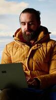 Vertical Workaholic explorer always connected and addicted to uninterrupted work, opening his laptop on the mountain top. Young hiker with internet dependency enjoys strong signal. Camera B. video