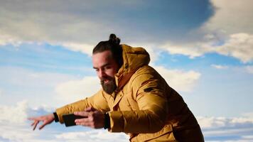 Reckless adventurer losing balance to take a picture and dropping phone off a cliff, falling down from a high altitude mountain range. Foolish hiker tries to take photos of a landscape. Camera B. video
