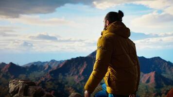 Hiker takes a moment to admire the panoramic view of mountains, looking into the distance and sightseeing. Fresh air, scenic background and peaceful surroundings for an explorer. Camera A. video