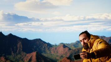 Foolish hiker acting careless dropping smartphone and losing balance, person unequipped for the harsh mountain environment. Risks of trekking with a technology obsession in nature. Camera B. video