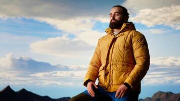 Proud explorer basks in the joy of accomplishment standing at the mountain peak with arms lifted, mindfulness. Traveler admiring stunning scenic view and vast sky for the thrill of hiking. Camera B. video