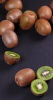 Kiwi fruit rotating and falling on black background video