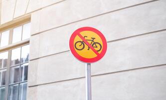 A no bike sign is on a pole in front of a building photo
