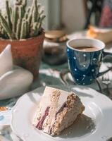 Close-up of a delicious cake slice with berry swirls, served with coffee in a polka dot mug photo