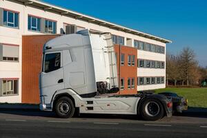 White truck parked near a modern building in clear weather photo