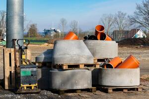 Construction site with concrete pipes and pallets in a sunny setting photo