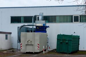 Industrial machinery working behind a factory building photo