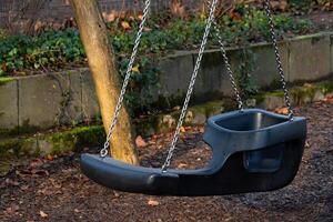 Swing set empty in a peaceful park during afternoon light photo