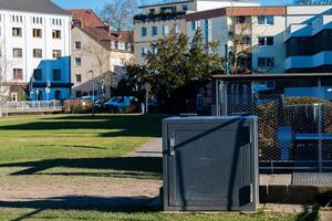 Urban park setting with nearby residential buildings and utility box photo
