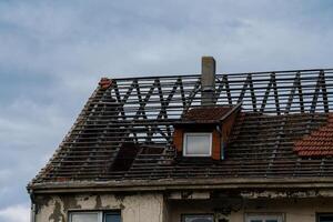 Roof renovation in progress on an old building under cloudy sky photo