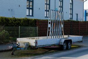 Car trailer parked by a building with a simple structure photo
