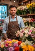 The clerk is a man wearing an apron and working in a flower shop photo