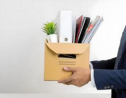 Resignation or Layoff Concept. Worker Holding a Box with Office Items and Documents photo