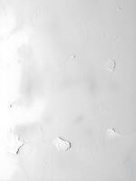 A white wall with peeling paint and some scratches photo