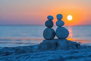 Two towers of stones stacked on top of each other on the seashore at sunset. Concept of romance and tranquility. photo