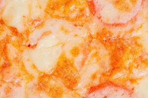 Pizza with sauce, cheese and tomatoes as a background. photo