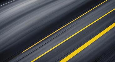 Curved asphalt road from a top view features smooth dark gray textures with yellow lines positioned diagonally for creative project backgrounds photo
